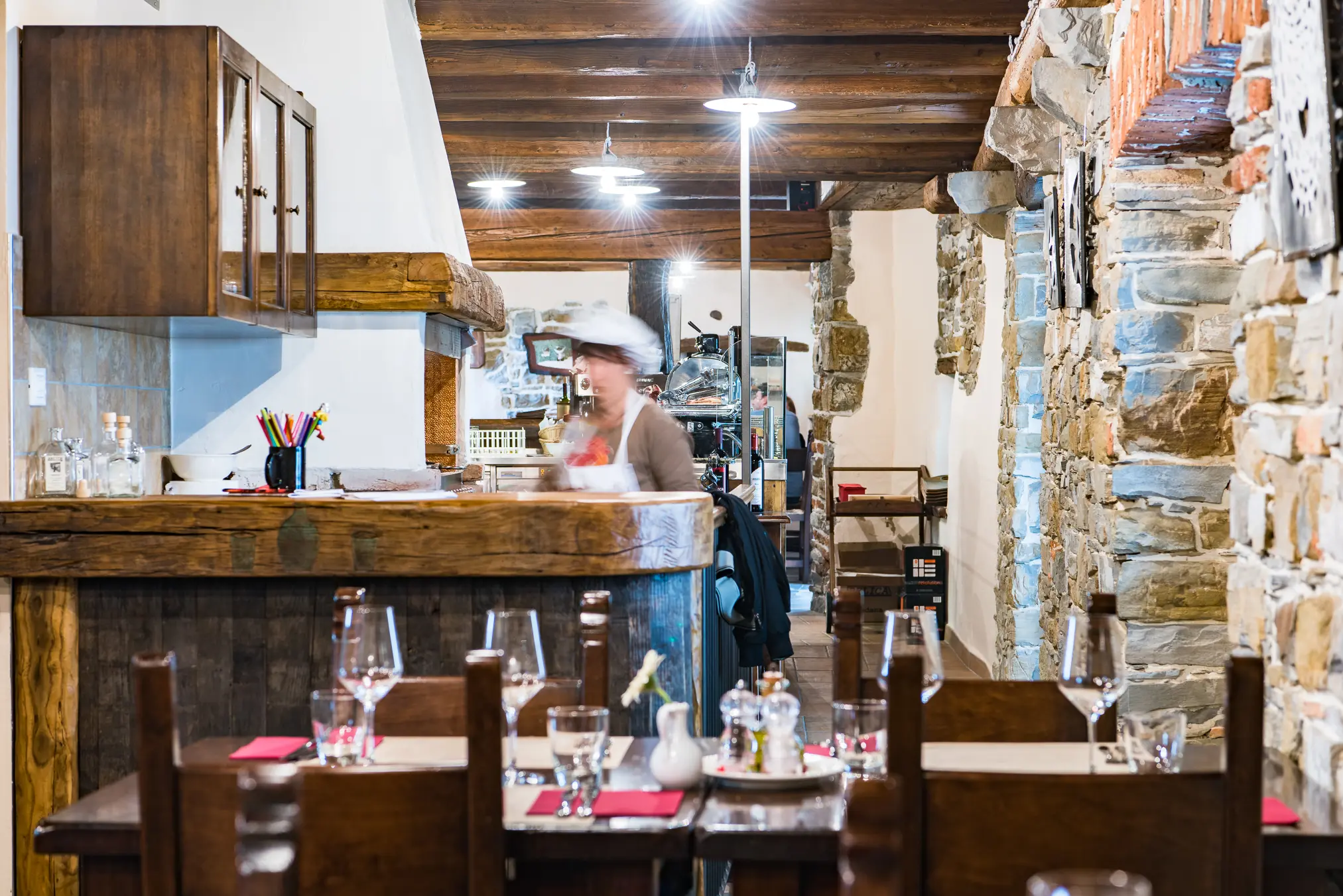 {"sl":"Restavracija s kamnitimi zidovi in lesenimi stropnimi tramovi. Natakarica se premika za pultom, mize so pripravljene za goste.","en":"","de":"","it":""}