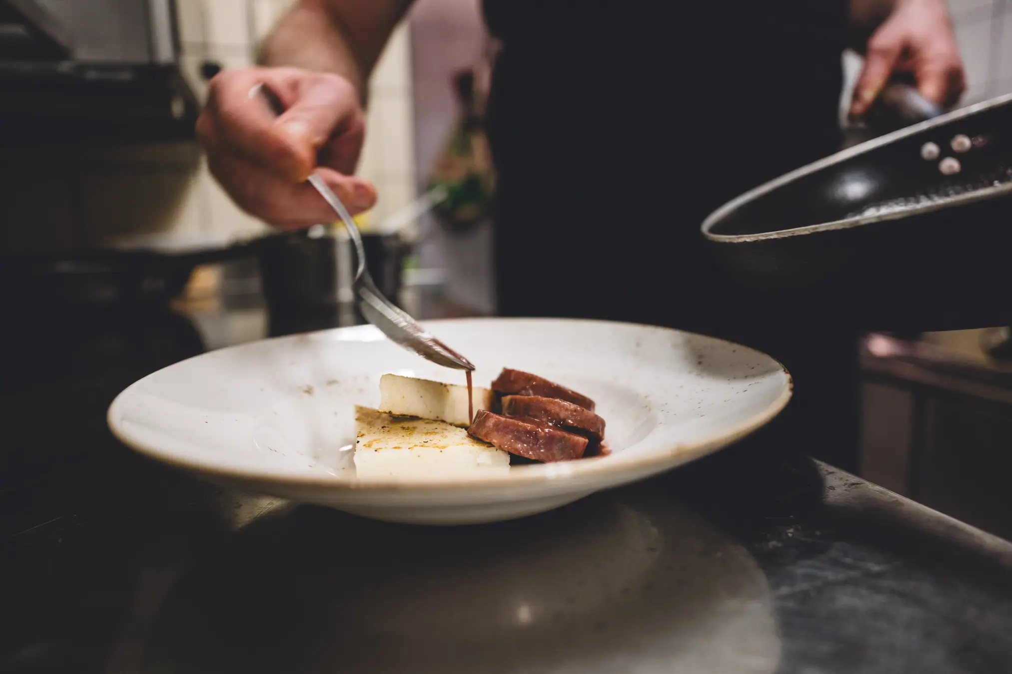 {"sl":"Kuhar pripravlja jed z rezinami sira in pe\u010denega mesa na kro\u017eniku","en":"","de":"","it":""}