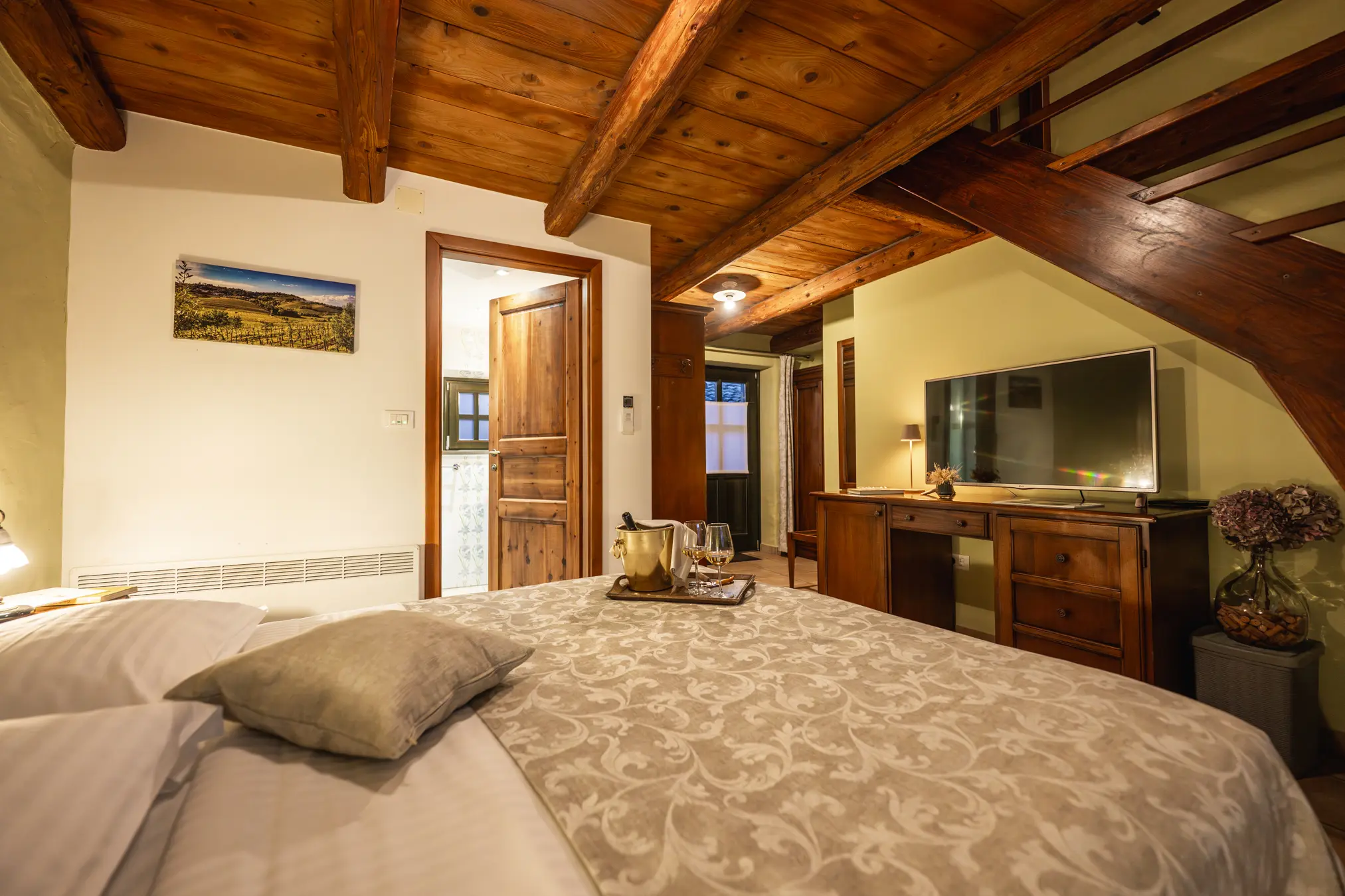 {"sl":"Notranjost rustikalne spalnice z lesenim stropom, udobno posteljo, TV-jem in hodnikom, osvetljeno s toplo svetlobo.","en":"","de":"","it":""}