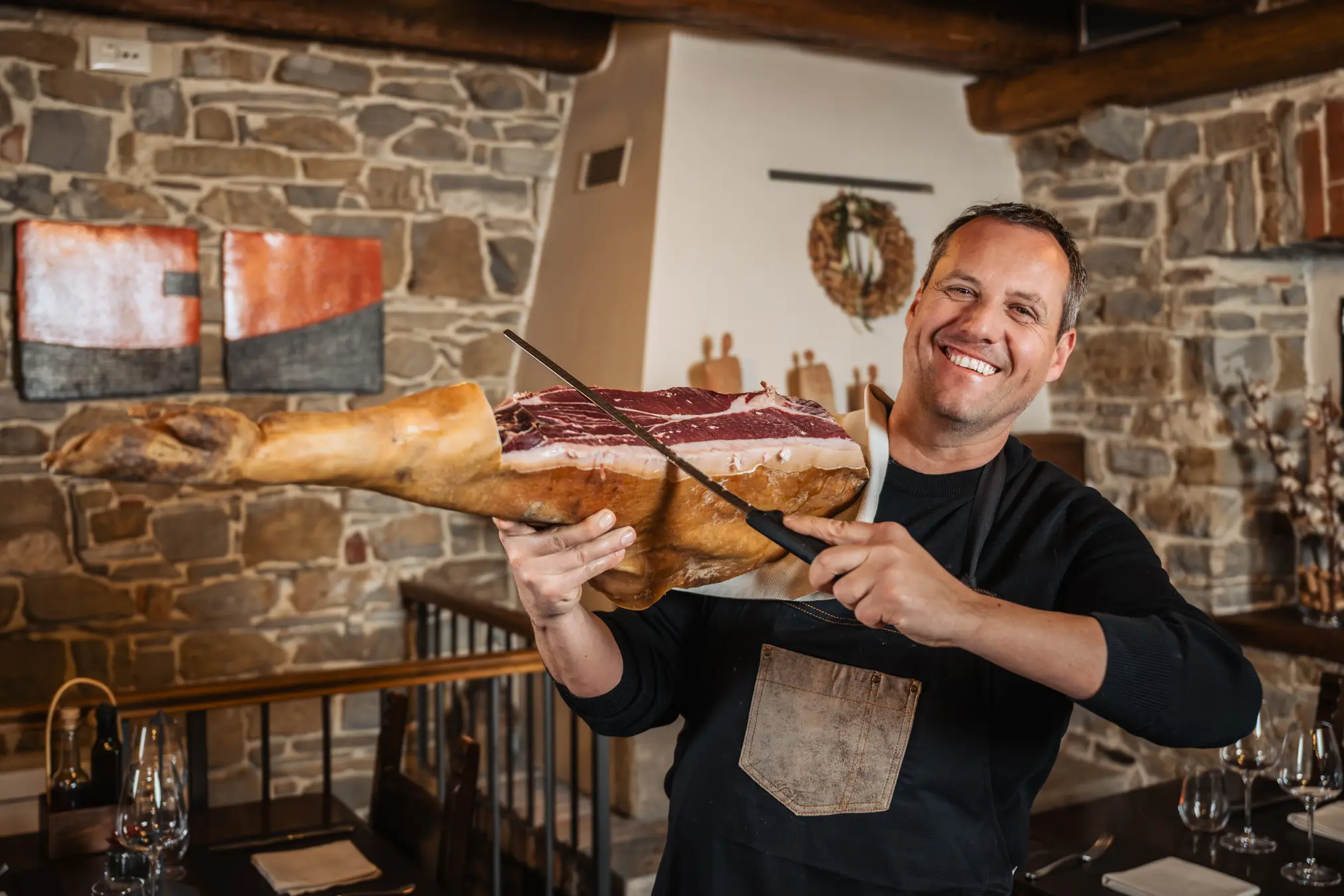 {"sl":"Nasmejan mo\u0161ki v restavraciji dr\u017ei velik kos su\u0161ene \u0161unke in ga re\u017ee z no\u017eem.","en":"","de":"","it":""}