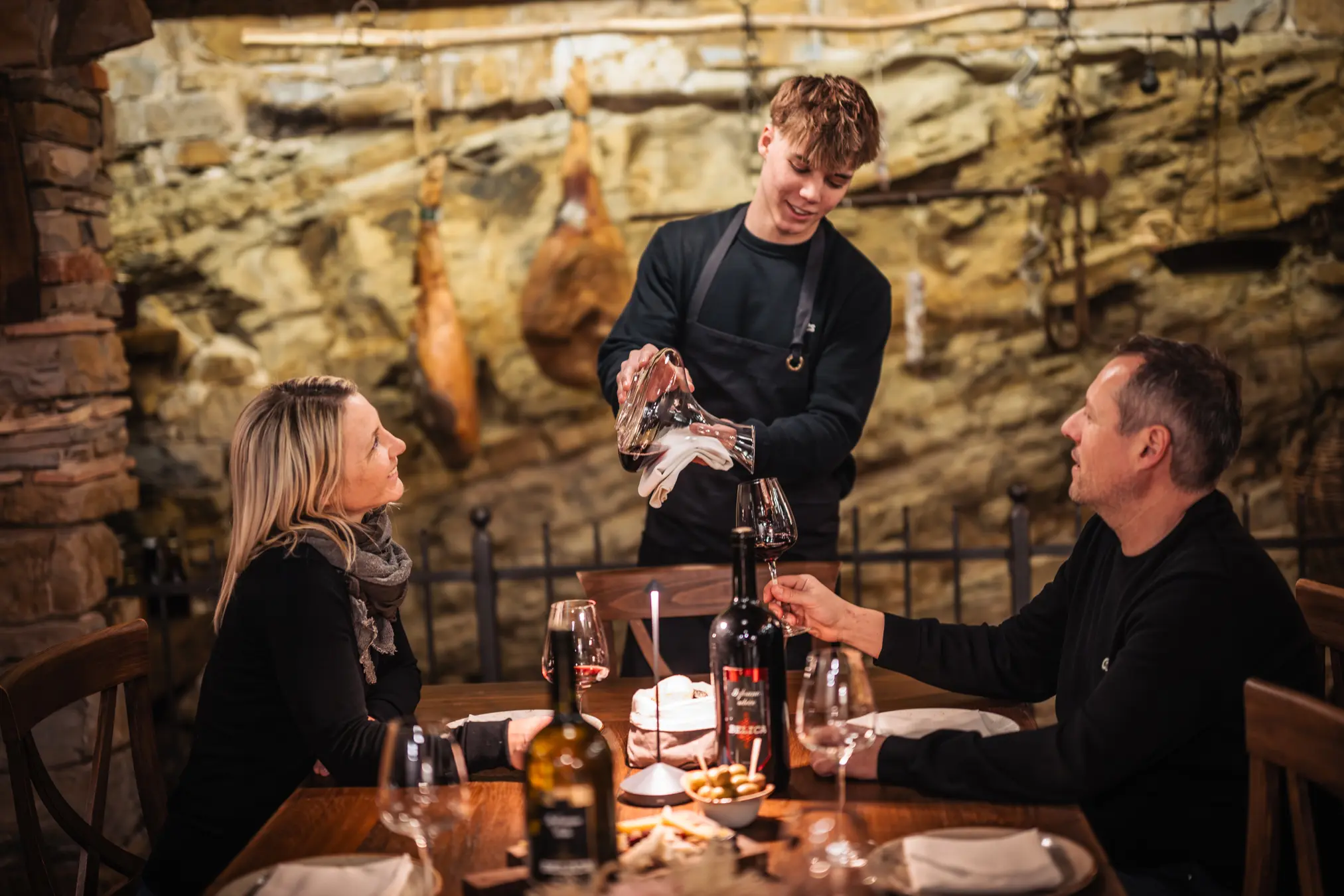 {"sl":"Natakar stre\u017ee vino parom, ki sedi za mizo v restavraciji z rustikalnim ambientom.","en":"","de":"","it":""}