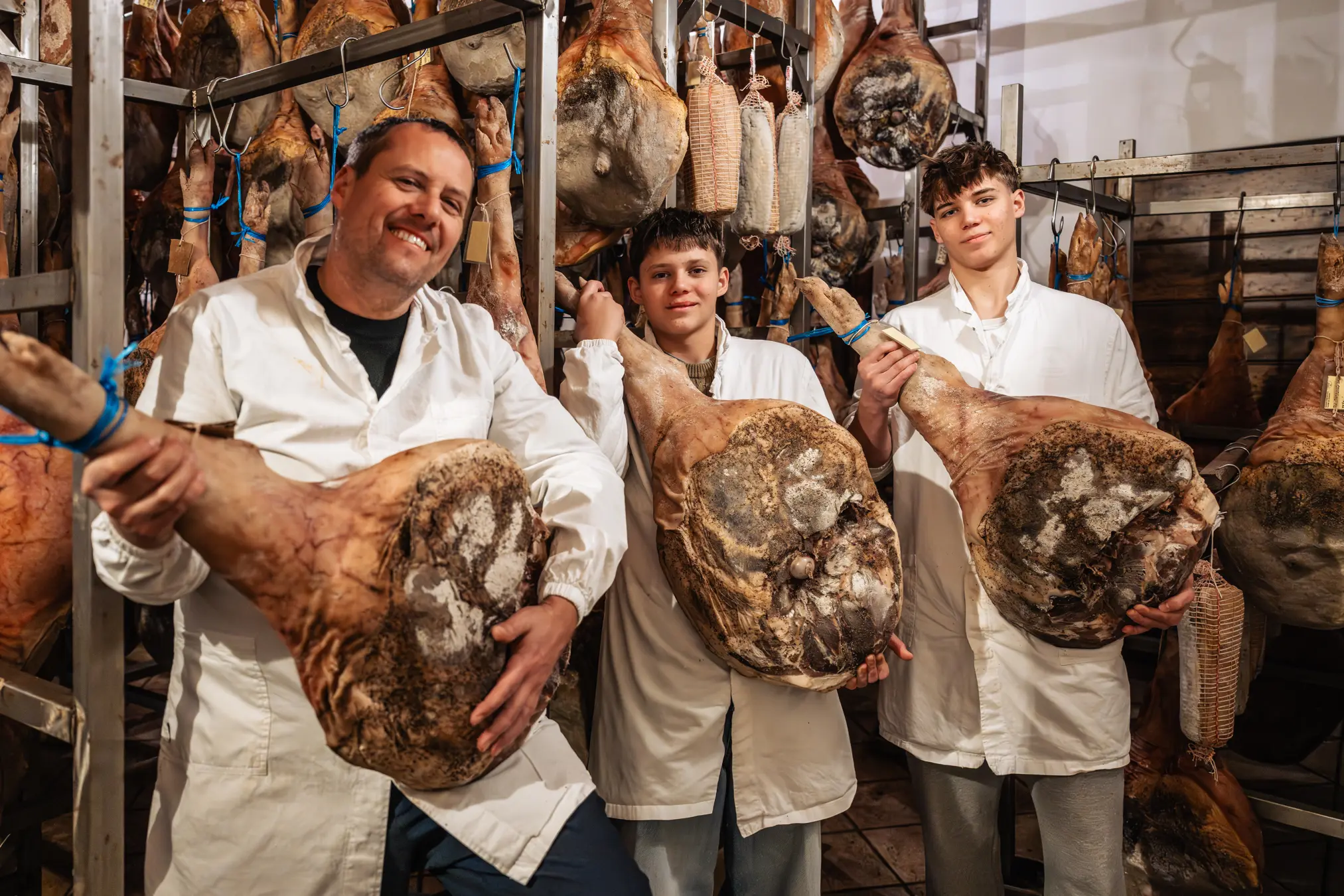 {"sl":"Tri osebe v belem delovnem obla\u010dilu dr\u017eijo pr\u0161ut v su\u0161ilnici, obkro\u017eeni z vise\u010dimi pr\u0161uti.","en":"","de":"","it":""}