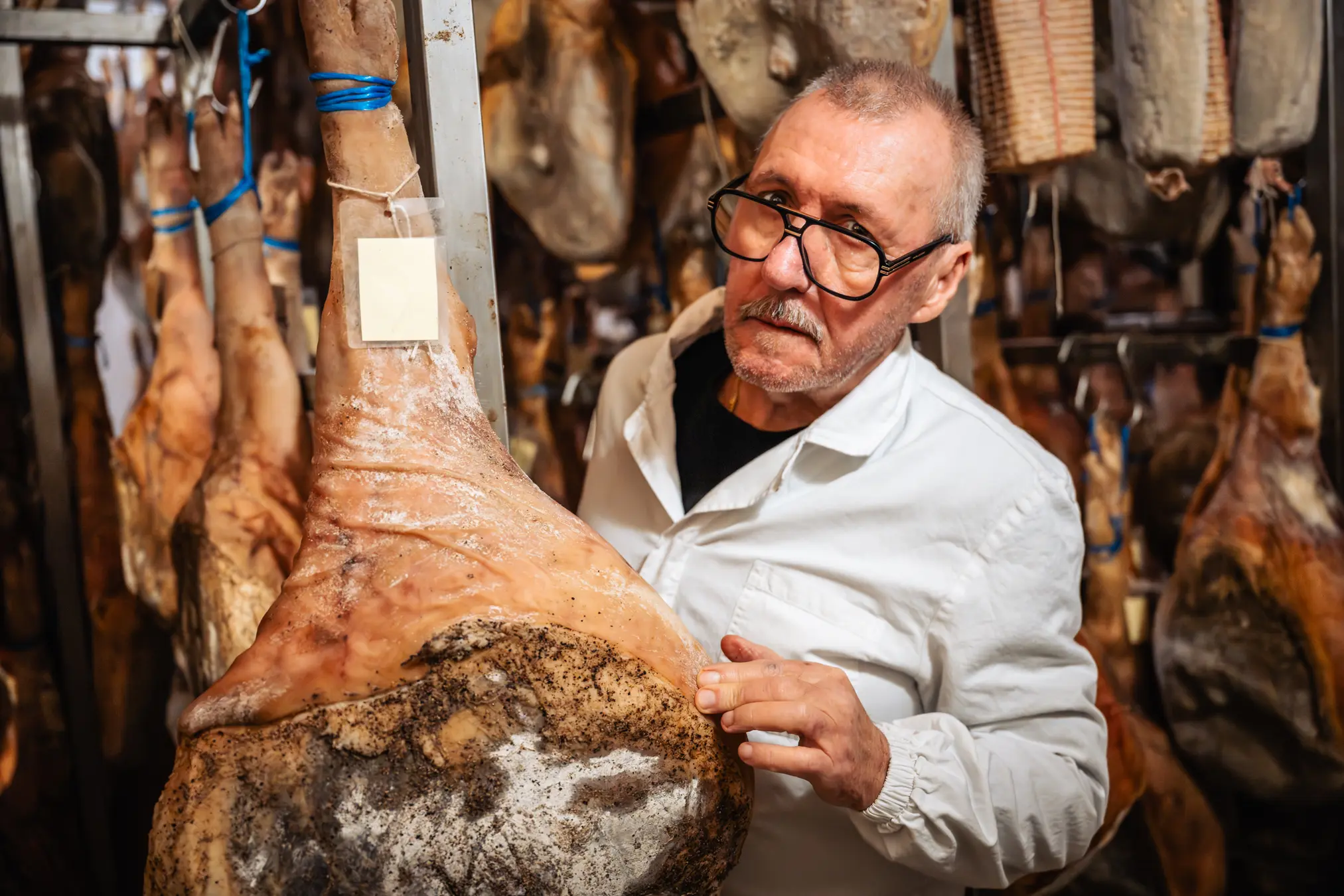 {"sl":"Mesar v belem pla\u0161\u010du pregleduje pr\u0161ut, obe\u0161en v su\u0161ilnici","en":"","de":"","it":""}