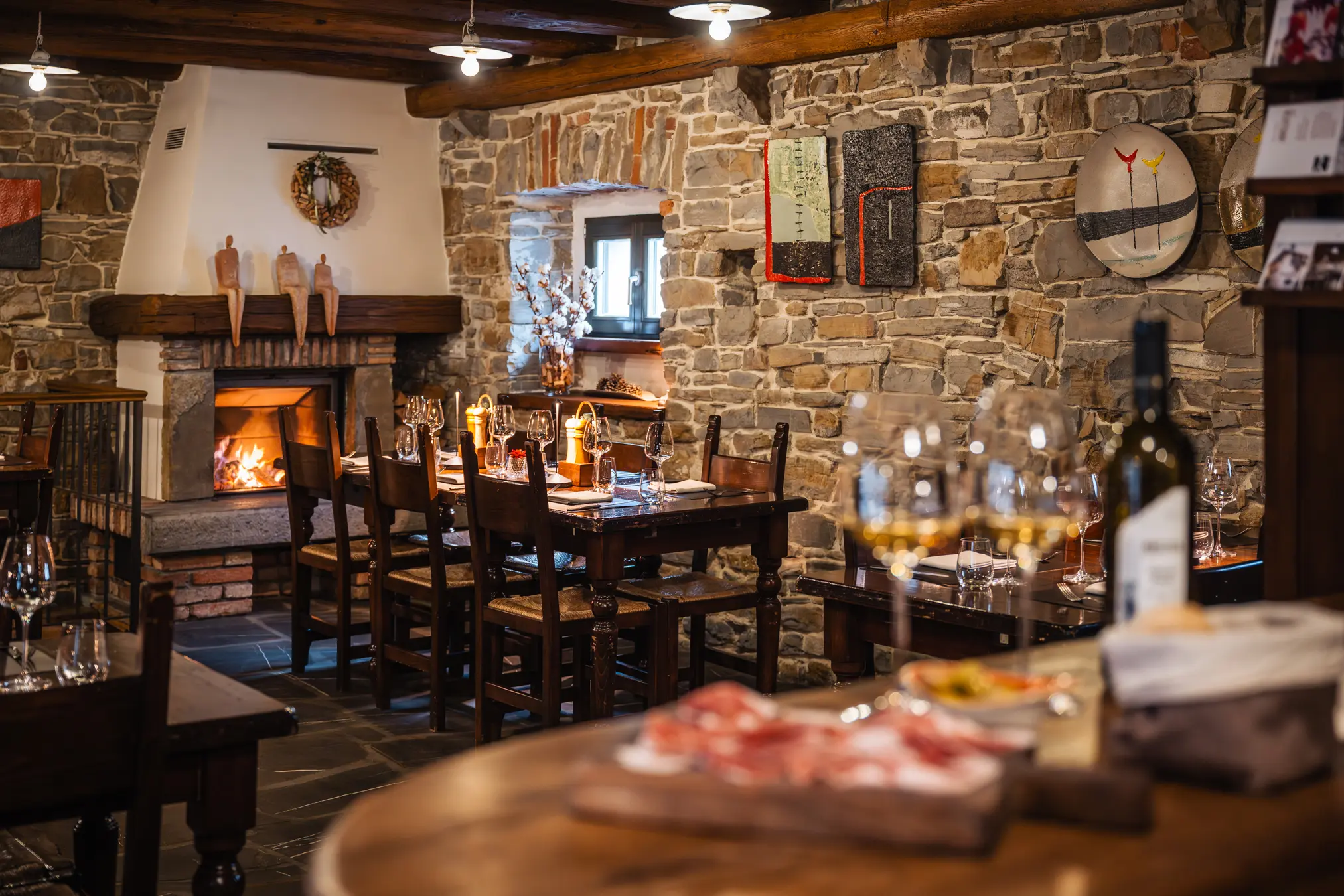 {"sl":"Notranjost rustikalne restavracije z lesenimi mizami, kaminom in kamnitimi zidovi, pripravljena za goste.","en":"","de":"","it":""}