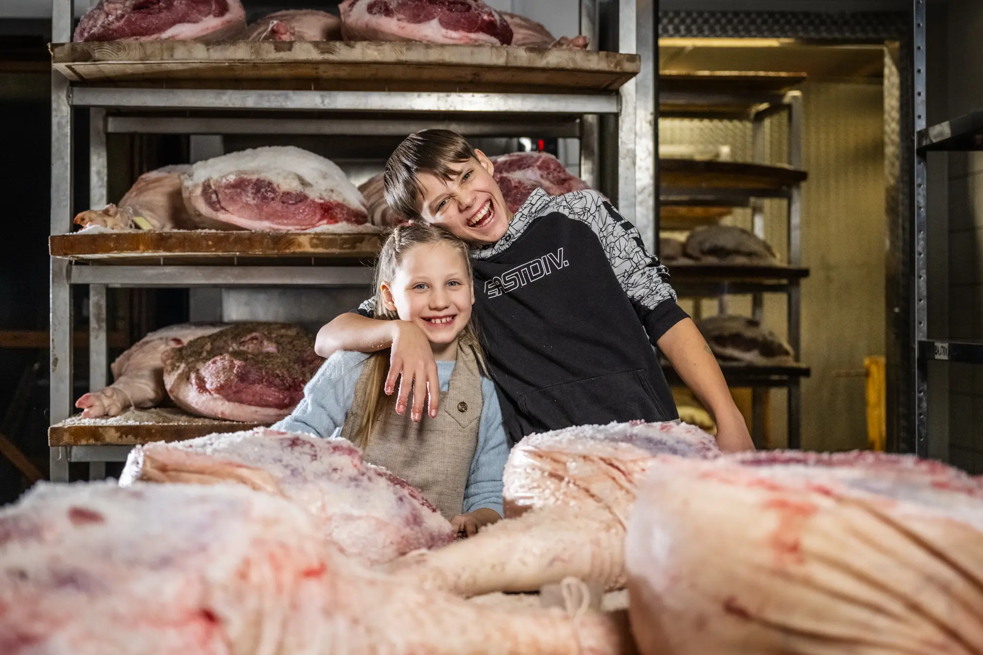 {"sl":"Dve nasmejani otroci stojita pred vise\u010dim mesom v su\u0161ilnici.","en":"","de":"","it":""}