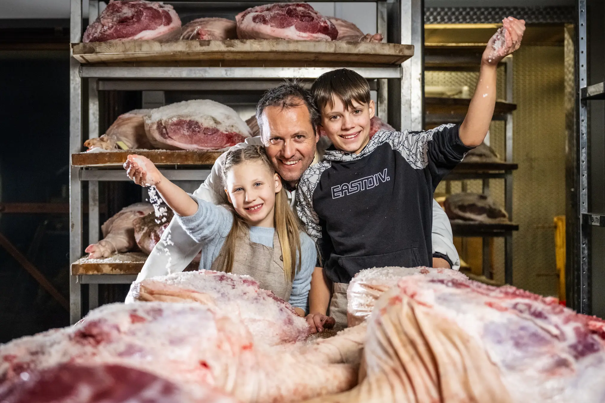 {"sl":"Moski z dvema otrokoma nasmejano stojijo ob kosih mesa na policah","en":"","de":"","it":""}